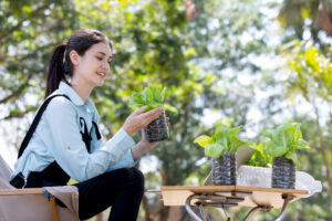 woman holding plant to learn sustainability and awareness